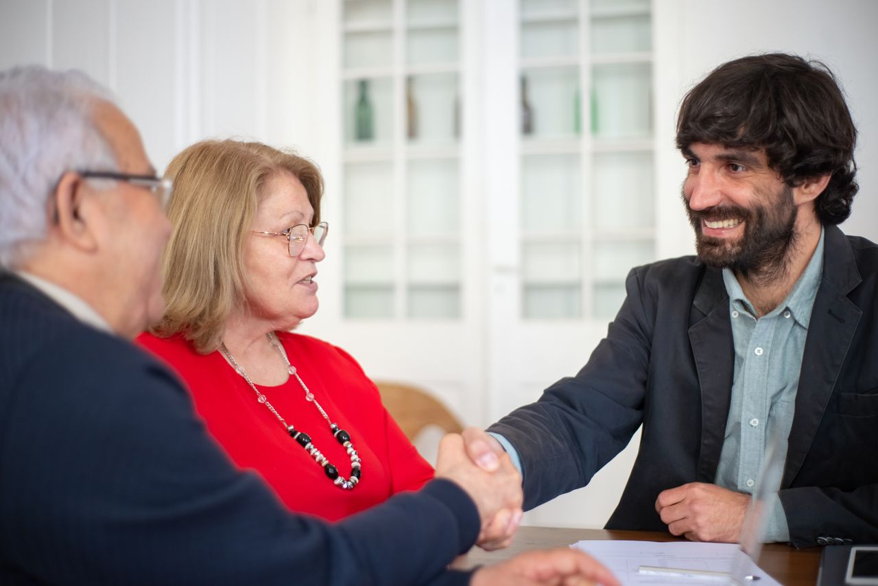 Services Business professionals engaged in a positive office meeting, sealing a deal with a handshake.